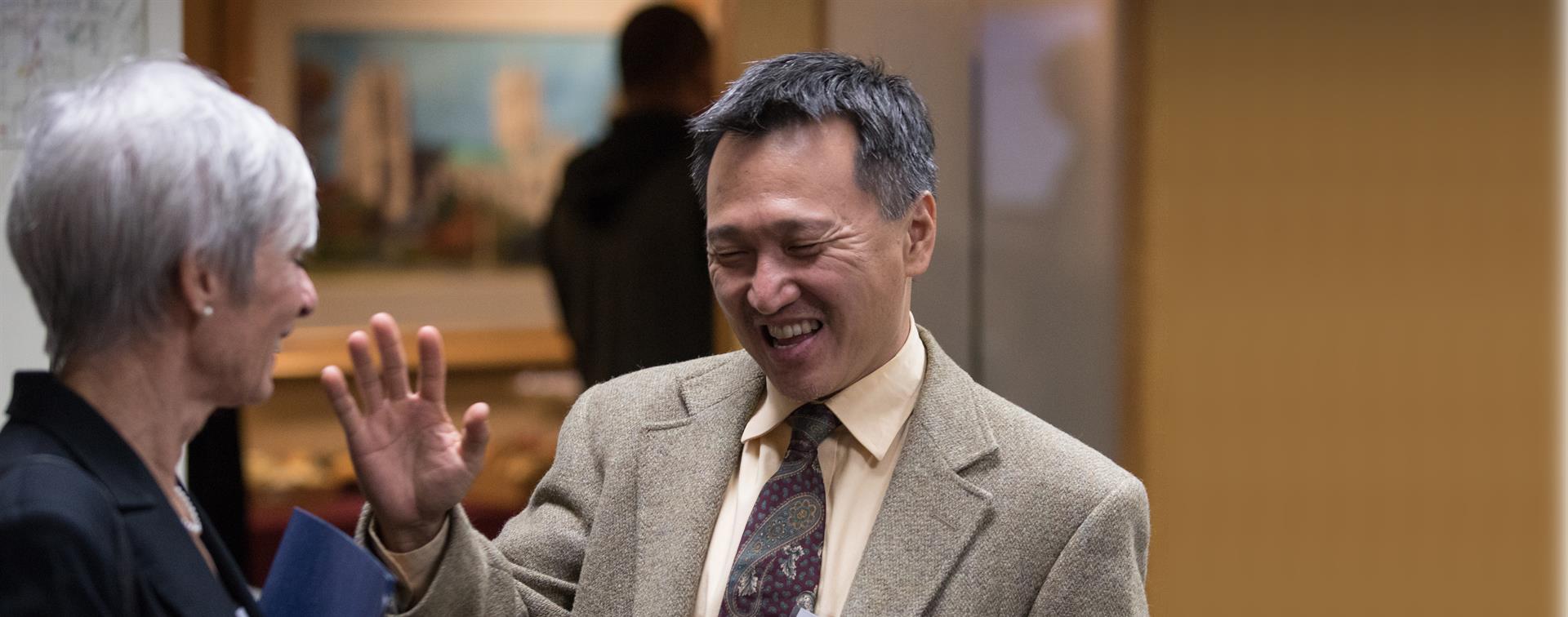 A picture of a man smiling and waving at the Internationalization Collaborative event