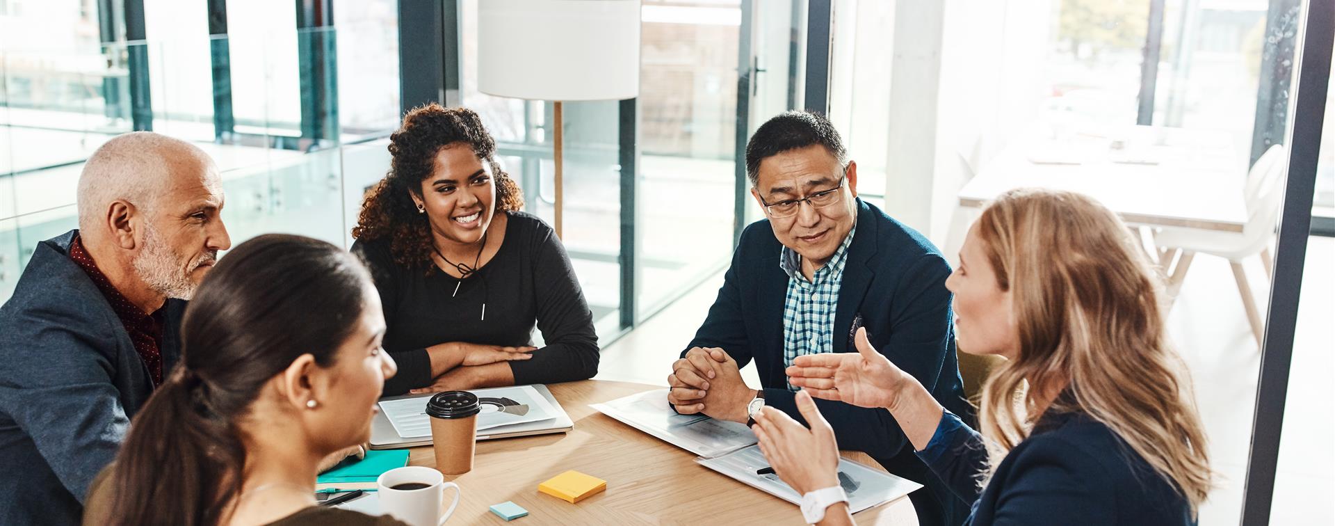 Picture of a professionals engaged in group discussion at a table