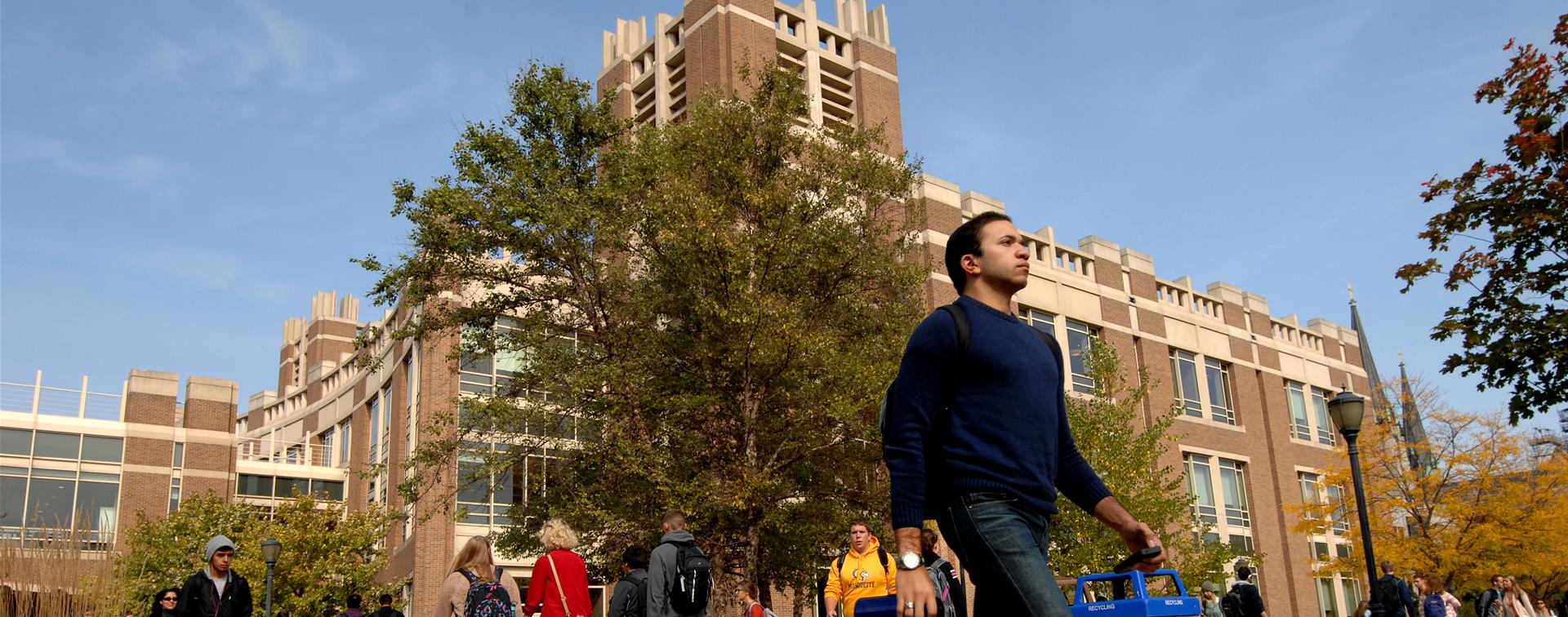 A picture of students walking across campus in the fall