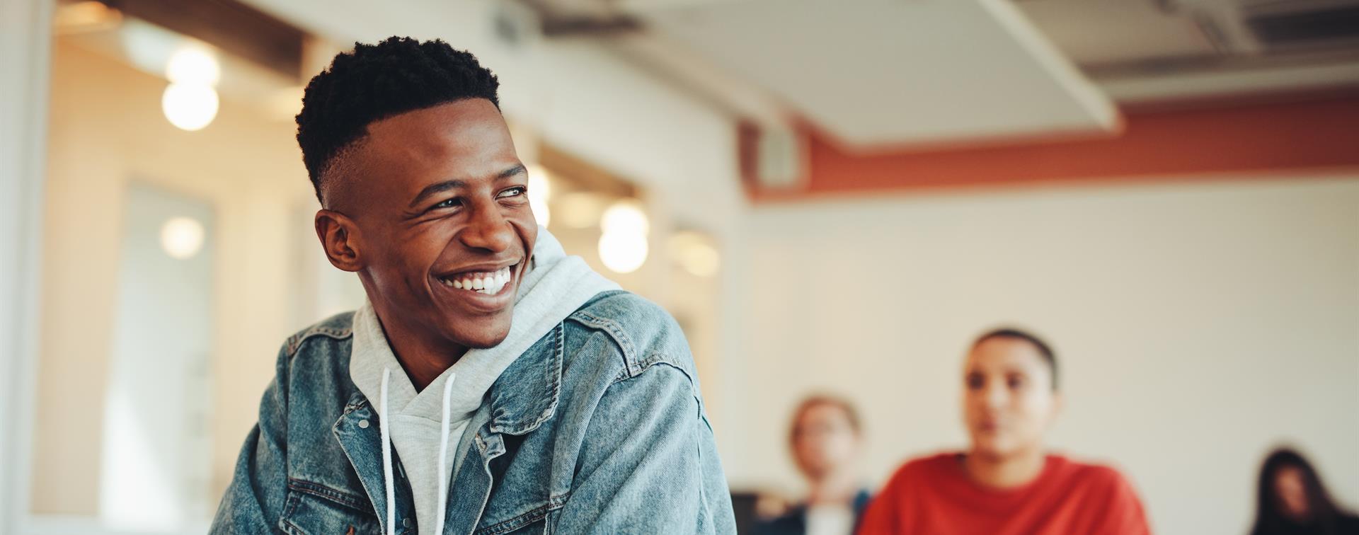 A student wearing denim jacket smiling