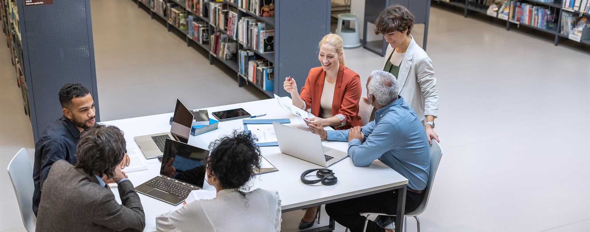 A group of people at a desk having a conversation