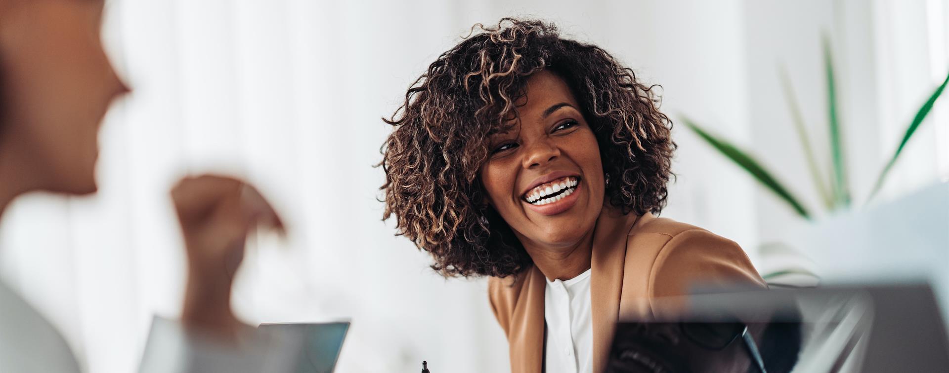 Picture of a woman laughing while working. 