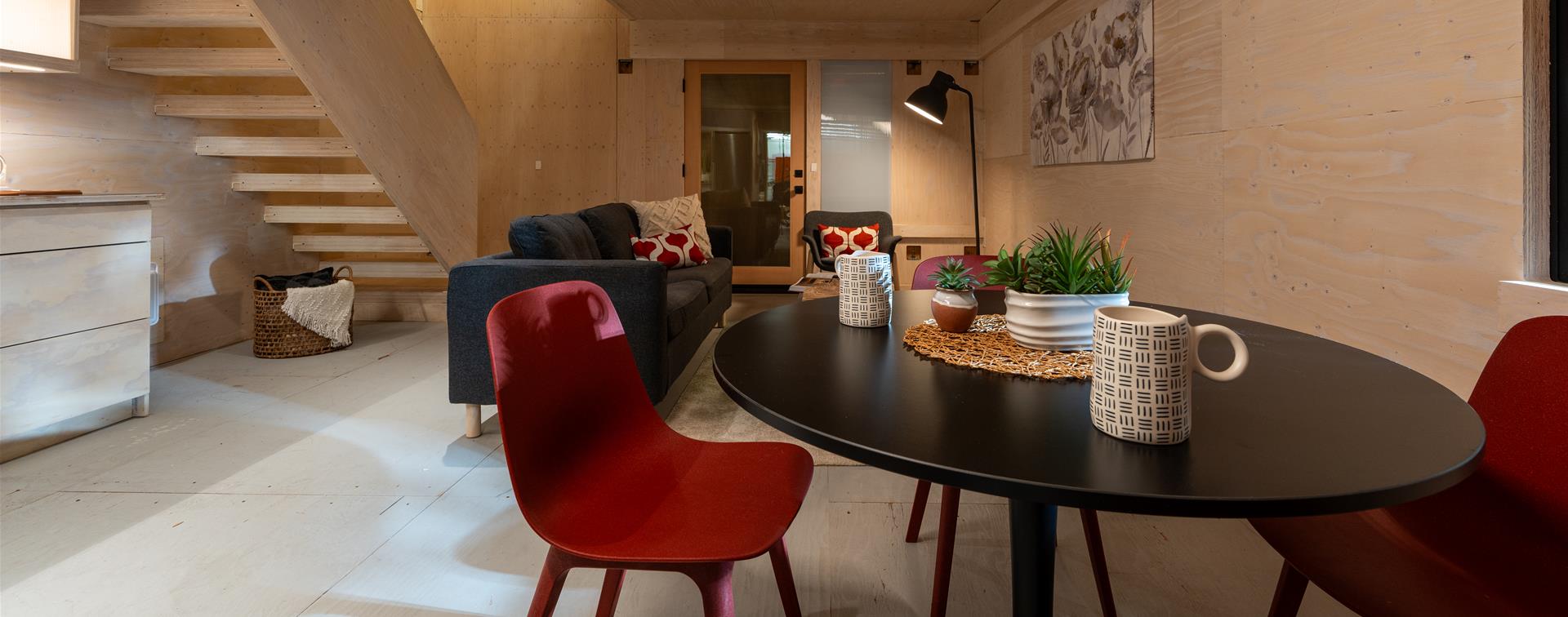 Photo of a minimalist living and dining area inside of a house built from plywood